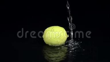 柠檬在水中，一滴<strong>纯净</strong>的水从上面倒在上面。 黑色<strong>背景</strong>。 慢动作